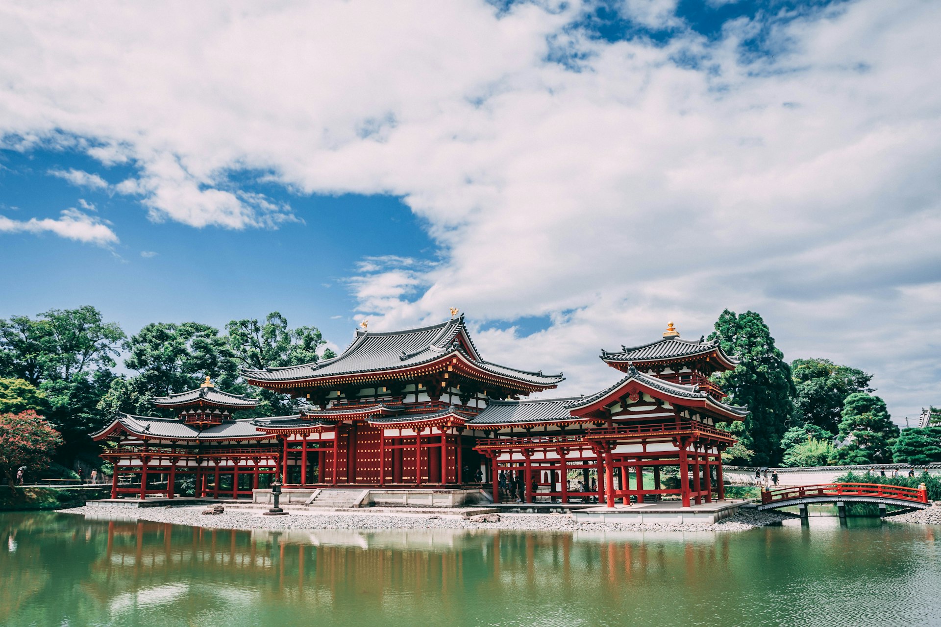 pagoda temple across body of water under blue cloudy sky